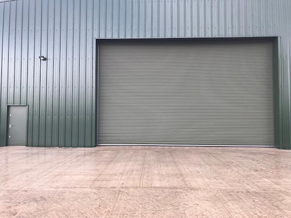 front of large bespoke hanger roller shutter and personnel access door